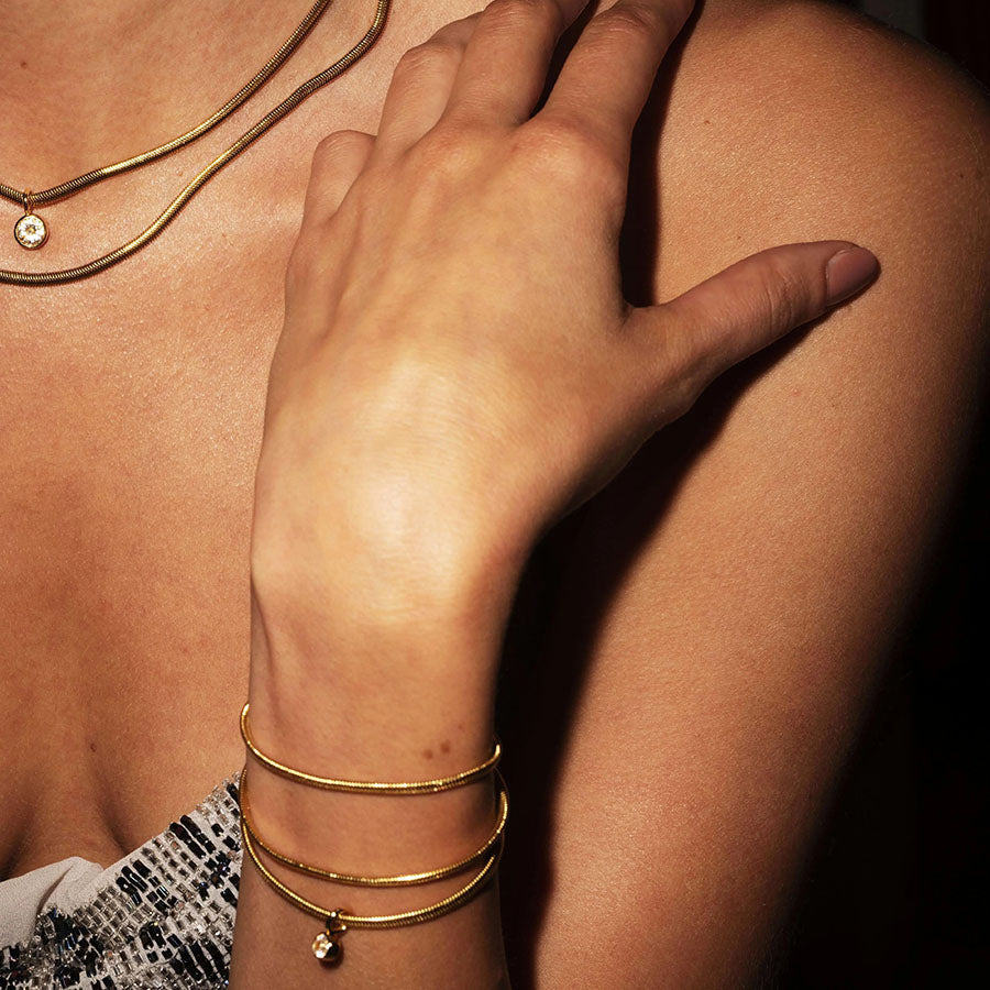 Bonheur Jewelry Lucile Gold Snake Chain Bracelet, 18k gold plated flat snake chain bracelet with Swarovski crystal, styled view.