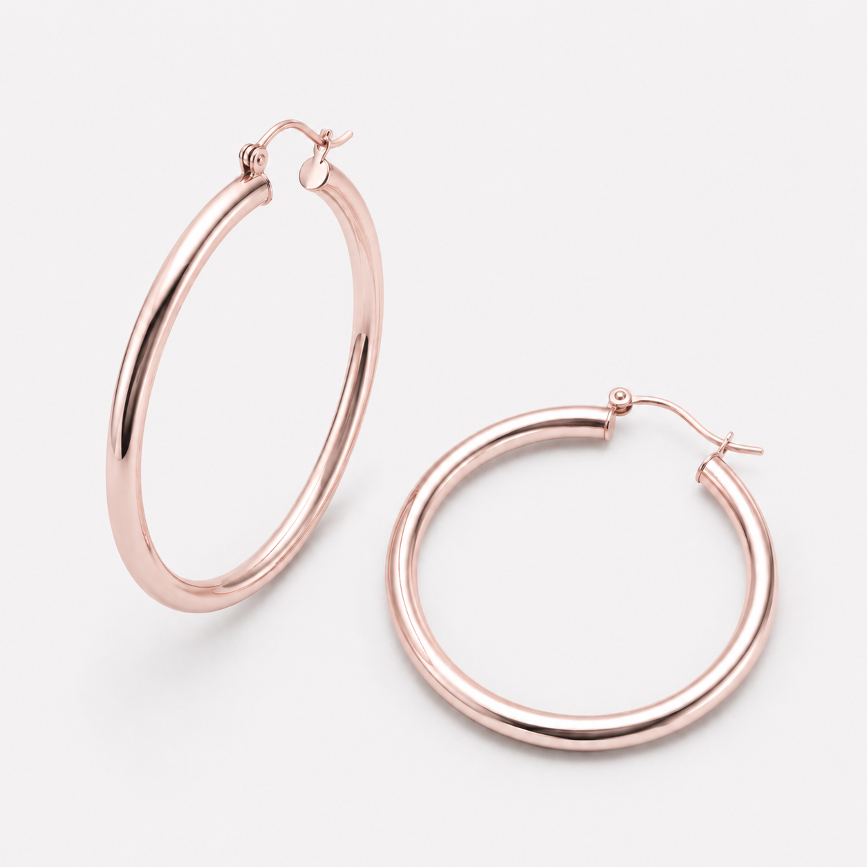 Bonheur Jewelry Selena Tube Hoop Earrings, gold, rose gold, or rhodium finish, polished metal, hoop earrings, styled view.