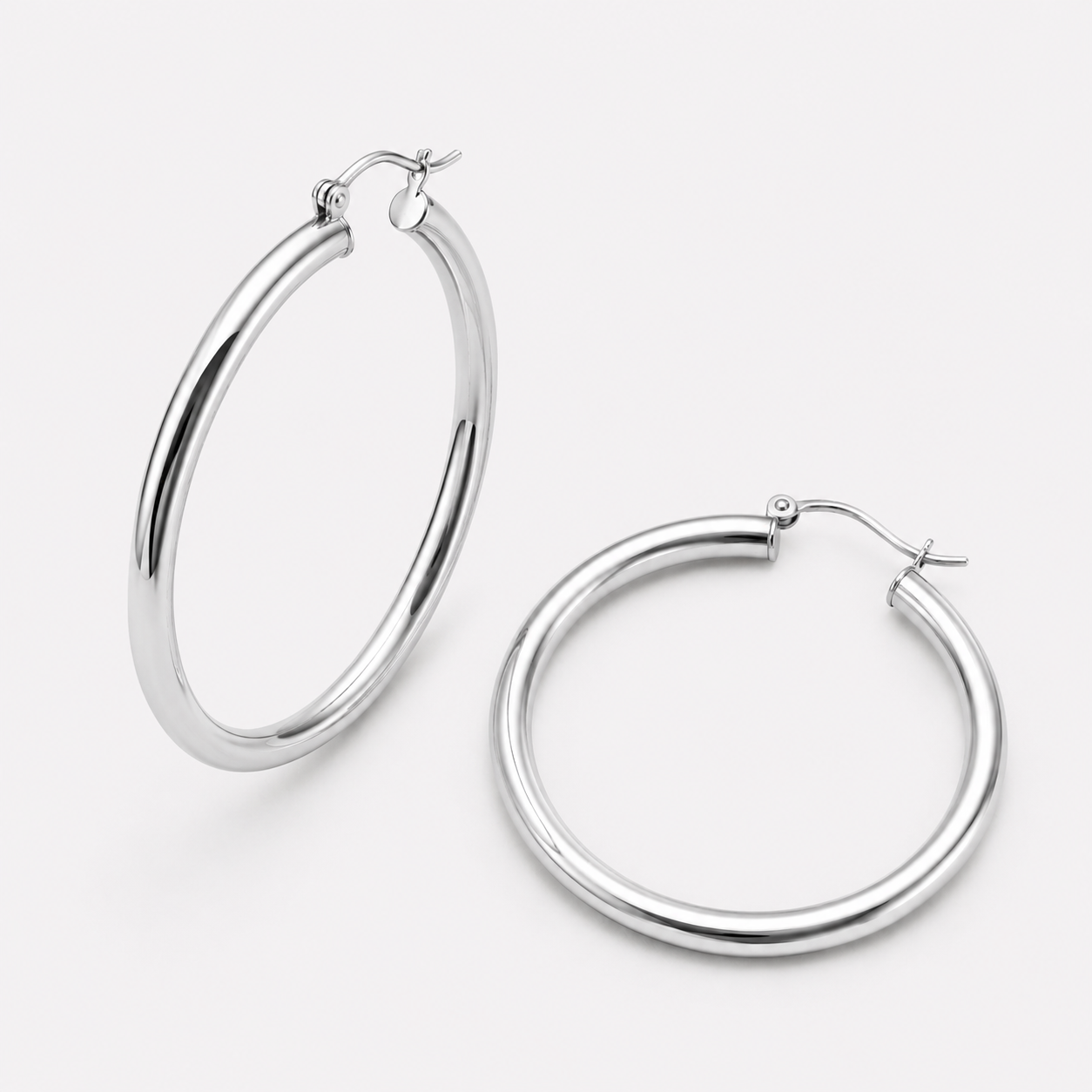 Bonheur Jewelry Selena Tube Hoop Earrings, gold, rose gold, or rhodium finish, polished metal, hoop earrings, styled view.