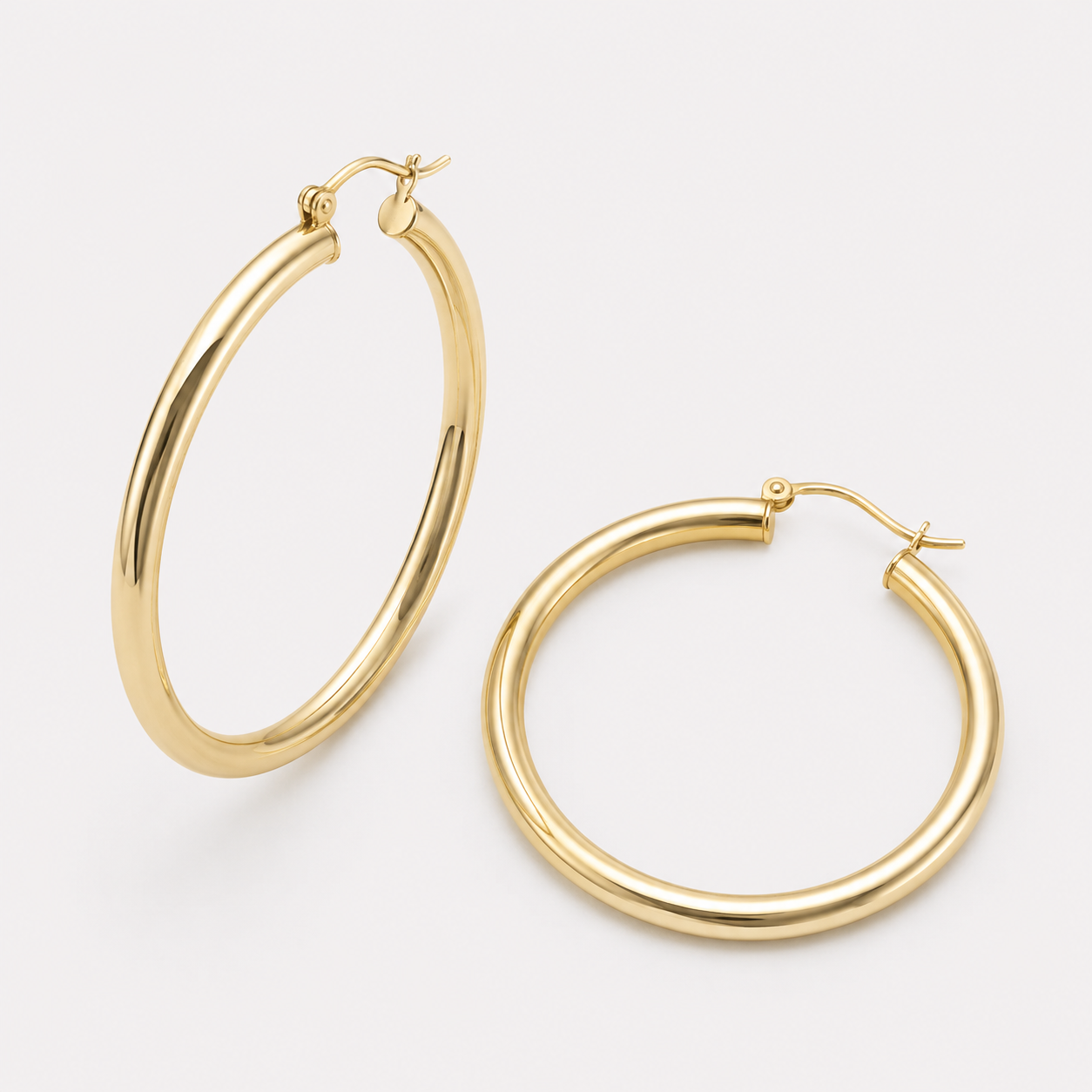 Bonheur Jewelry Selena Tube Hoop Earrings, gold, rose gold, or rhodium finish, polished metal, hoop earrings, styled view.