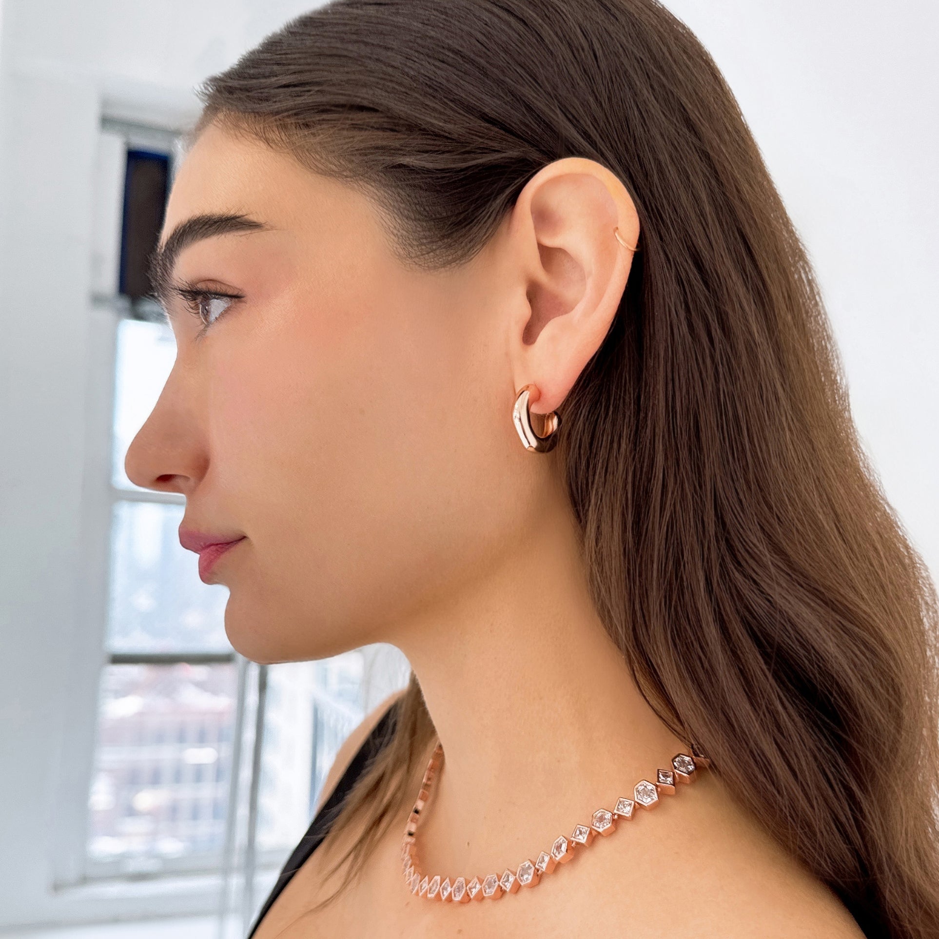 Model wearing Lya Bubble Earrings by Bonheur Jewelry, lightweight bubble earrings with a polished sculptural hoop silhouette.